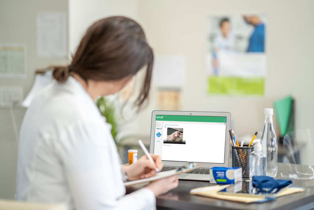 dr using patient education on laptop