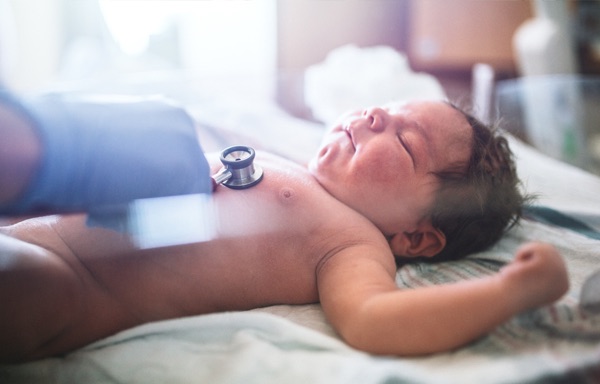 Pic: Doctor placing stethoscope on distressed baby's chest